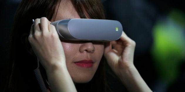 A woman uses the LG 360 VR glasses during the LG unpacked 2016 event on the eve of this weeks Mobile World Congress wireless show, in Barcelona, Spain, Sunday, Feb. 21. 2016. (AP Photo/Manu Fernandez)