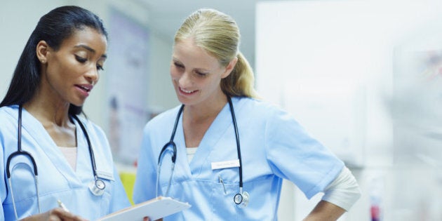 Young female nurses discussing over medical documents in hospital