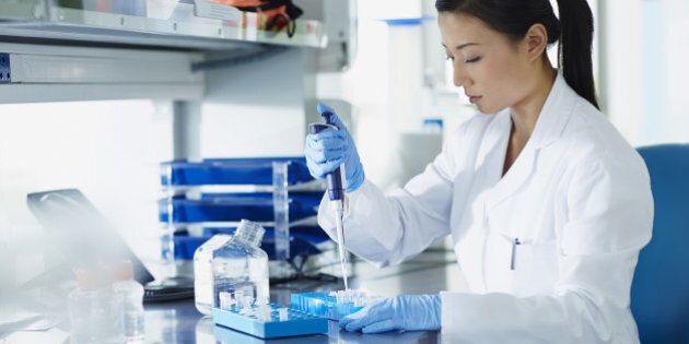 Scientist pipetting samples into eppendorf tubes in research laboratory