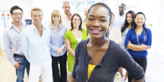 Beautiful young woman with colleagues in the background