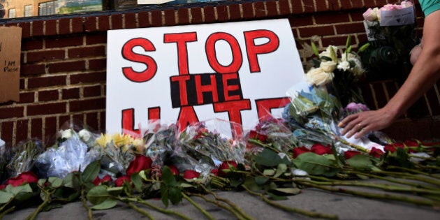 A man lays flowers at a memorial outside The Stonewall Inn on Christopher Street, considered by some as the center of New York State's gay rights movement, following the shooting massacre at Orlando's Pulse nightclub, in the Manhattan borough of New York, U.S., June 12, 2016. REUTERS/Mark Kauzlarich