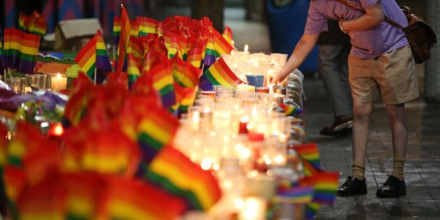 A man looks over an impromptu candle-lit memorial set up in Sydney, Monday, June 13, 2016, following the Florida mass shooting at the Pulse Orlando nightclub where police say a gunman wielding an assault-type rifle opened fire, killing at least 50 people and wounding dozens. Australian Prime Minister Malcolm Turnbull said that the Orlando mass shooting was
