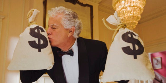 Wealthy man kissing money bags