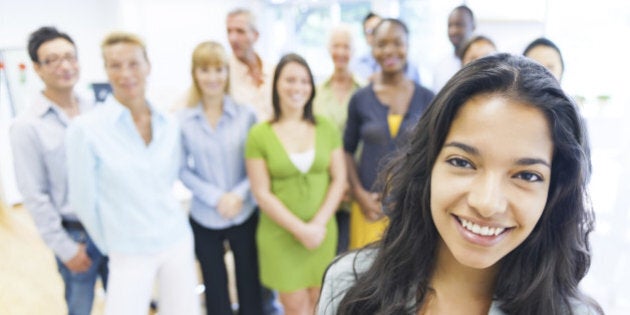 Beautiful young woman with colleagues in the background