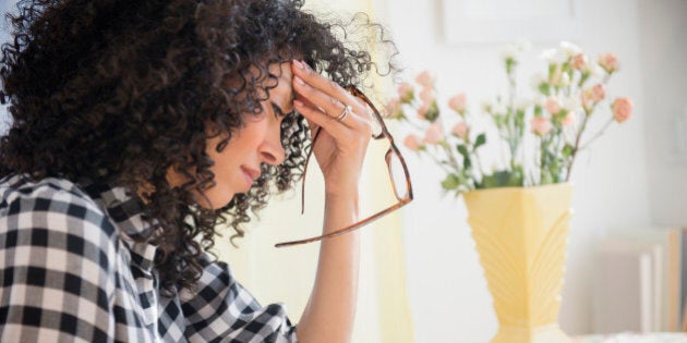 Anxious mixed race woman sitting at table