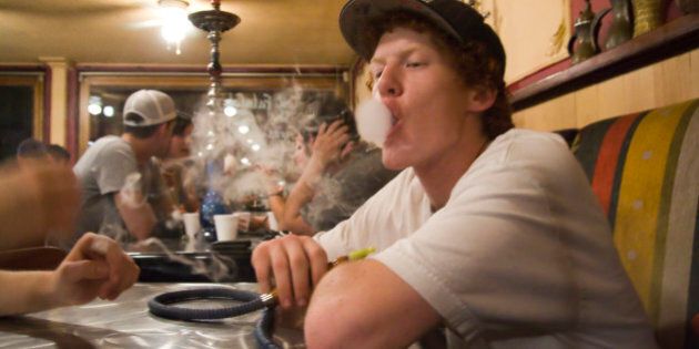 A young man smokes hookah at Zaina in downtown Seattle, Washington.