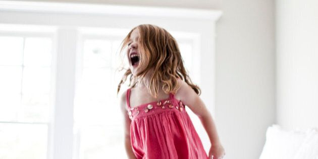daughter jumping and screaming on bed