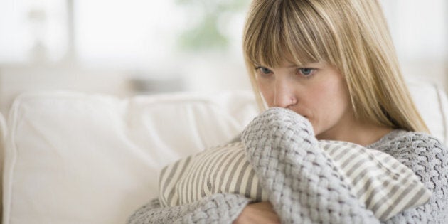 Woman sitting on sofa and thinking