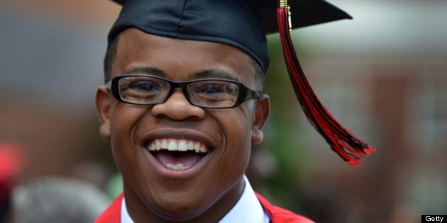 WASHINGTON, DC - JUNE 14: Johnathon Carrington, valedictorian at Dunbar High School, laughs with family and friends after his school's graduation ceremony at Howard University on Friday, June 14, 2013, in Washington, DC. Carrington, who grew up in Tyler House public-housing apartments and is graduating from one of DC's low-performing high schools, plans to attend Georgetown University, where academic expectations are high. (Photo by Jahi Chikwendiu/The Washington Post via Getty Images)