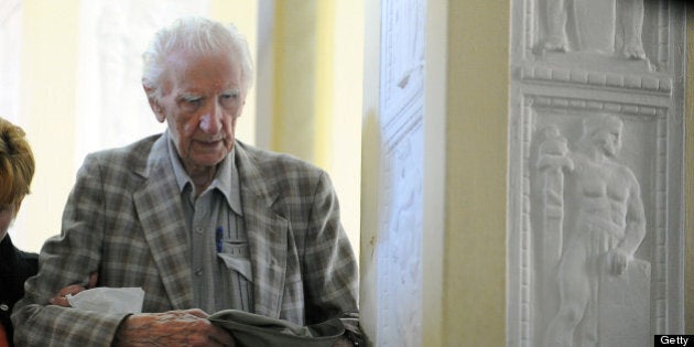 Laszlo Csatary (L), aka Ladislaus Csizsik-Csatary, leaves the courthouse in Budapest on July 18, 2012, after he was placed under house arrest for 30 days following questioning by an investigative judge at the military's prosecution's office. Meanwhile the Simon Wiesenthal Centre welcomed the arrest by Hungarian police of the Nazi war crimes suspect, who topped the US Nazi-hunting organisation's most wanted list. Csatary is accused by the Wiesenthal Center of having helped organise the deportation of some 15,700 Jews to the Auschwitz death camp during World War II. AFP PHOTO / ATTILA KISBENEDEK (Photo credit should read ATTILA KISBENEDEK/AFP/GettyImages)