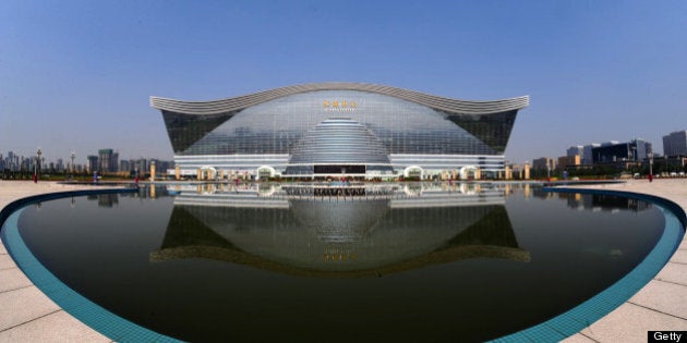 The 'New Century Global Centre' building is seen behind an artificial lake in Chengdu, in southwest China's Sichuan province on June 6, 2013. The center, claimed by Chinese officials as 'the world's largest standalone structure', is going to be opened to the public on June 28. The 100m high 'New Century Global Centre' is a symbol of the spread of China's boom: 500m long and 400m wide, with 1.7 million square metres of floor space - big enough to hold 20 Sydney Opera Houses, according to local authorities. CHINA OUT AFP PHOTO (Photo credit should read STR/AFP/Getty Images)