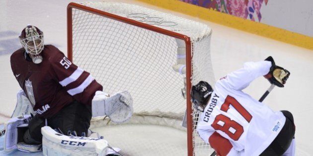 Canada's Sidney Crosby (R) fails to score past Latvia's goalkeeper Kristers Gudlevskis during the Men's Ice Hockey Quarterfinals Canada vs Latvia at the Bolshoy Ice Dome during the Sochi Winter Olympics on February 19, 2014. Canada won 2-1. AFP PHOTO / ALEXANDER NEMENOV (Photo credit should read ALEXANDER NEMENOV/AFP/Getty Images)