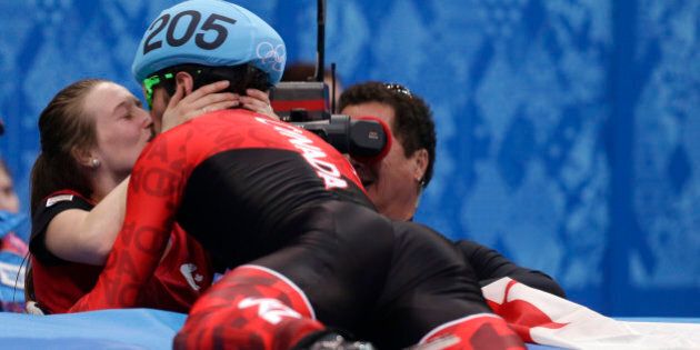 Charles Hamelin of Canada, right, embraces Marianne St. Gelais after he won the men's 1500m short track speedskating final at the Iceberg Skating Palace during the 2014 Winter Olympics, Monday, Feb. 10, 2014, in Sochi, Russia. (AP Photo/Darron Cummings)