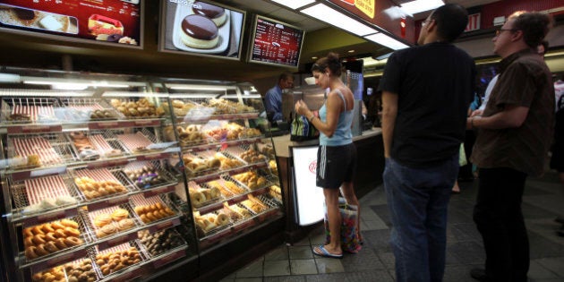 Costumers line up at the Tim Hortons coffee shop inside New York's Penn Station, Monday, July 13, 2009. Canadian doughnut and coffee chain Tim Hortons Inc. said it is opening 12 new locations in New York City, with three more planned for August. (AP Photo/Mary Altaffer)