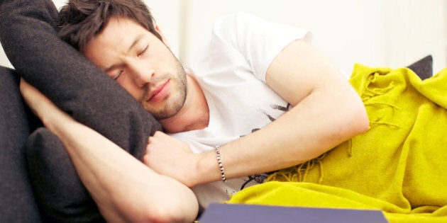 Young Asian man in a deep exhausted sleep after studying from his book.