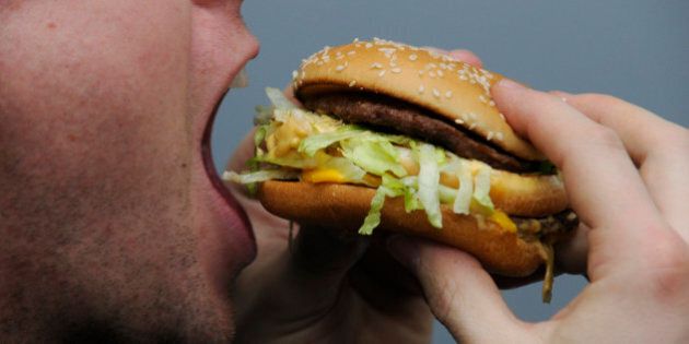 A man eats a Big Mac from McDonald's.