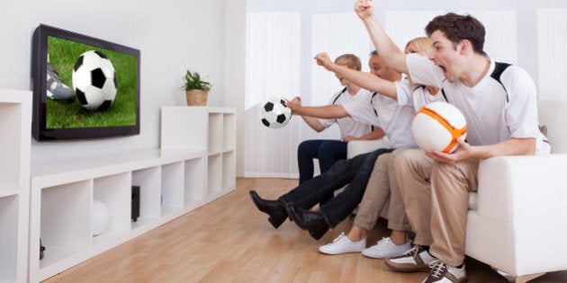 Jubilant family watching television as they cheer on their home side in a sporting competition