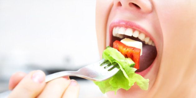 close-up of woman eating fresh salad