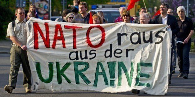 Protestors hold a banner reading 'Nato get out of the Ukraine' in front of the Westin Hotel where the German-Russian forum 'Petersburg Dialogue' takes place in Leipzig, eastern Germany, on April 23, 2014. The Petersburg Dialogue brings together representatives from civil society. AFP PHOTO / ROBERT MICHAEL (Photo credit should read ROBERT MICHAEL/AFP/Getty Images)