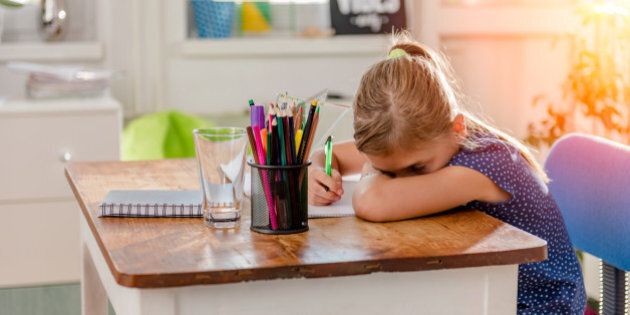 Girl in blue shirt having problem with concentration to finish home work