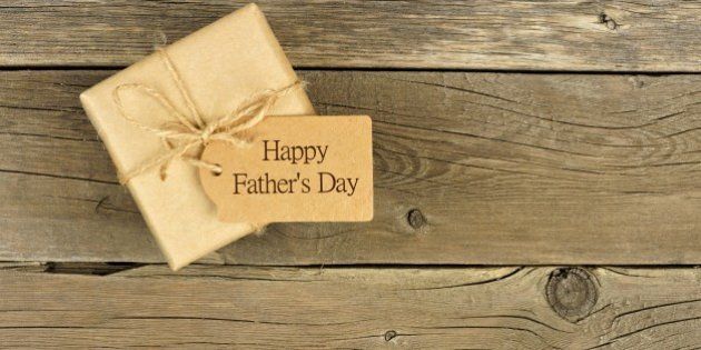 Brown Fathers Day gift box with tag on a rustic wood background