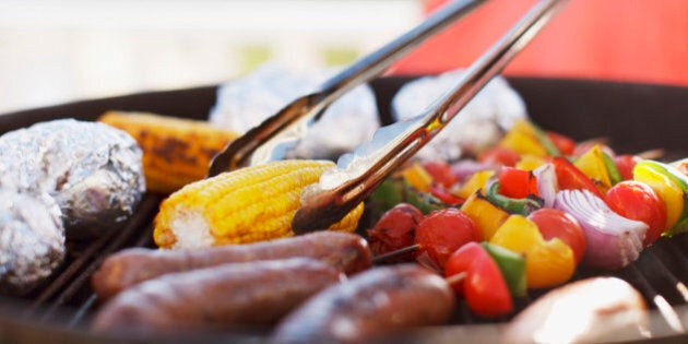 Close up of man grilling food on barbecue