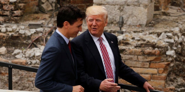 U.S. President Donald Trump talks to Canadian Prime Minister Justin Trudeau following a family phto at the Greek Theatre during a G7 summit in Taormina, Sicily, Italy, May 26, 2017. REUTERS/Jonathan Ernst