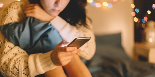 Girl texting on smartphone at home