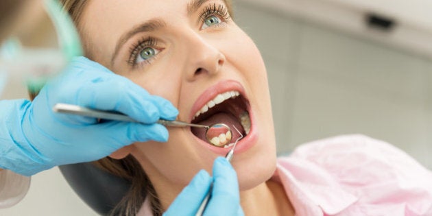 Horizontal color close-up headshot of beautiful woman having dental examination.