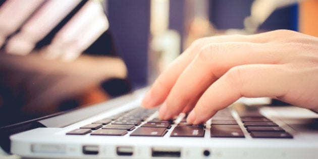 Female hands typing on keyboard of laptop