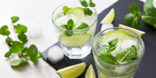 Cold refreshing summer lemonade mojito in a glass on a slate board and stone background