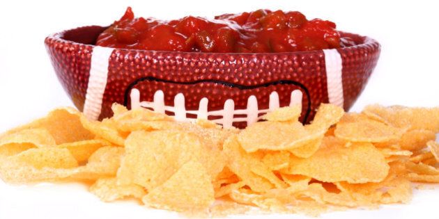 ceramic football dish with salsa in it surrounded by chips