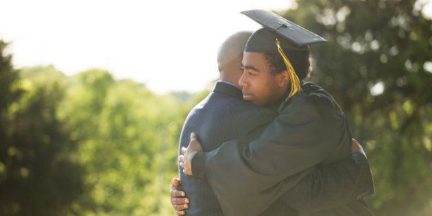African American Father hugging his son graduation day