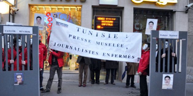 Members of Reporters without Borders (RSF) hold a banner reading 'Tunisia: muzzled press, prisoned journalists' as they protest to call for the release of Hedi Zoghlami (R) and Tunisian journalist Taoufik Ben Brik on November 18, 2009 in Paris. Ben Brik, 41, was arrested after an alleged altercation with a woman and charged with violating public decency, defamation, assault and damaging private property. His is currently being held at Mornaguia prison, 20km north of Tunis and his trial is scheduled to begin on November 19th. AFP PHOTO ARTHUR HERBULOT (Photo credit should read ARTHUR HERBULOT/AFP/Getty Images)