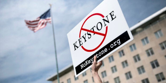 An activist holds up a sign outside the State Department during a protest of the Keystone XL pipeline on March 7, 2014 in Washington. Activists organized by the Energy Action Coalition marched to the State Department to protest the construction of the pipeline which would carry tar sands oil from Canada. AFP PHOTO/Brendan SMIALOWSKI (Photo credit should read BRENDAN SMIALOWSKI/AFP/Getty Images)