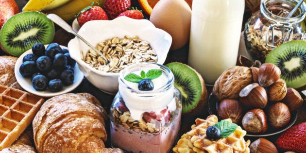 Health breakfast - with homemade granola, waffles, muffins,almond,hazelnuts,various fresh fruits, berries and milk on old wooden table. Health food concept .Top view.