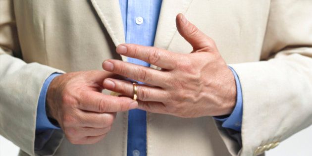Divorced man taking off wedding ring