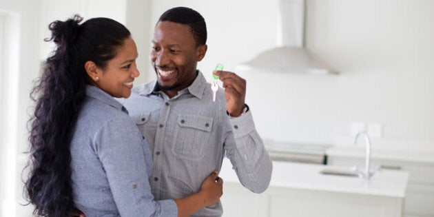 Couple hugging and holding keys in new home