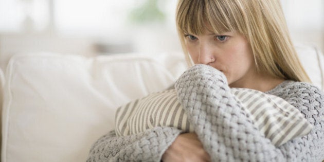 Woman sitting on sofa and thinking