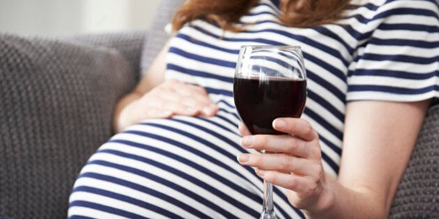 Close Up Of Pregnant Woman Drinking Red Wine
