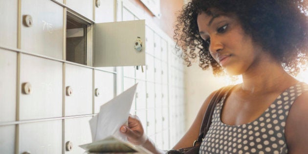 Mixed race businesswoman checking mailbox