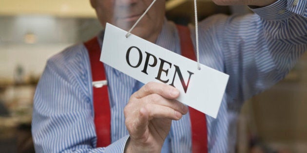 Man hanging open sign on door