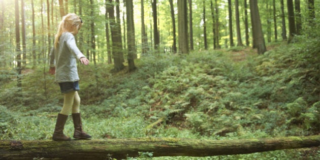 Girl walking on a tree trunk