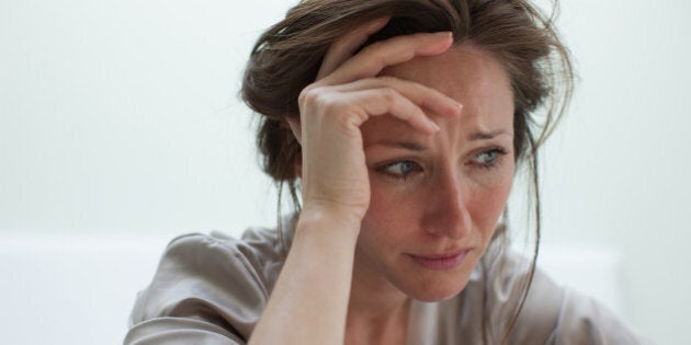 Depressed woman with head in hands
