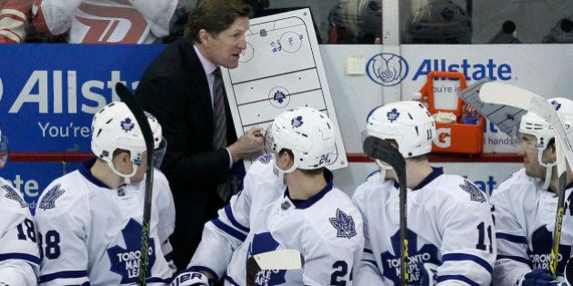 Toronto Maple Leafs head coach Mike Babcock draws up a play for Toronto Maple Leafs' Colin Greening (38), Peter Holland and Zach Hyman (11) during the third period of an NHL hockey game against the Detroit Red Wings Sunday, March 13, 2016, in Detroit. (AP Photo/Duane Burleson)