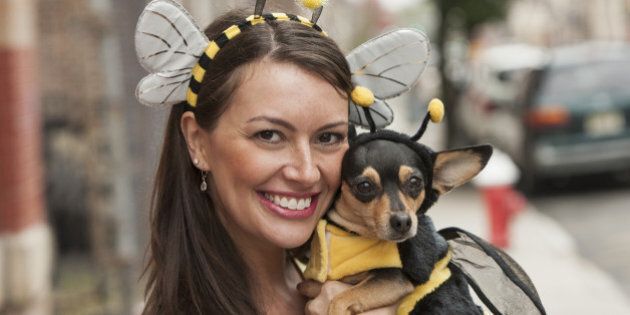 Caucasian woman and dog in bee costumes