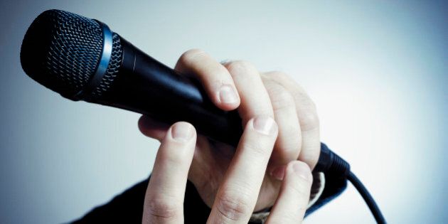 Close-up of a person's hand holding a microphone