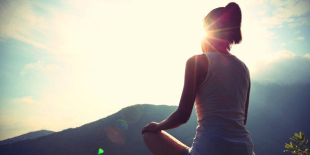 young yoga woman at sunrise mountain peak