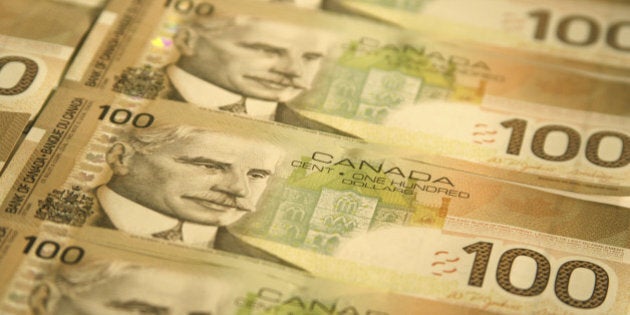 'A group of Canadian $100 bills lined up in rows. Focus is on the face of Prime Minister Robert Borden on the second bill from the bottom, softening above and below.'