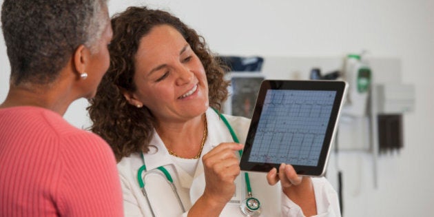 Doctor showing patient test results on digital tablet